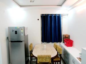 a kitchen with a table with chairs and a refrigerator at Serenity Homes Near Rushikonda in Visakhapatnam