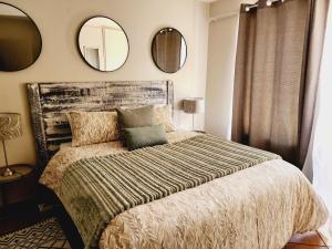 1 dormitorio con 1 cama grande y 2 espejos en la pared en Blue Button, en Pretoria