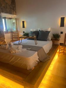 ein großes Bett in einem Zimmer mit einem Tisch darauf in der Unterkunft La Posada de Botavara in Madrid