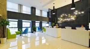 a lobby with a woman sitting at a desk at Echarm Hotel Guiyang International Convention & Exhibition Center in Guiyang
