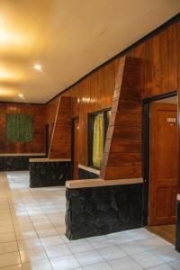 Un vestíbulo con paredes de madera y una escalera. en Cemara Indah Hotel, en Bromo 101 fotos más