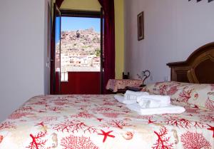 um quarto com uma cama com toalhas e uma janela em B&B Nonna Sini em Castelsardo
