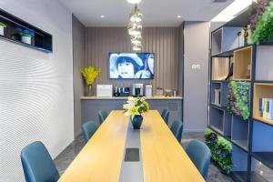 a conference room with a long wooden table and blue chairs at Home Inn Selected Xiamen University Zhongshan Road in Xiamen