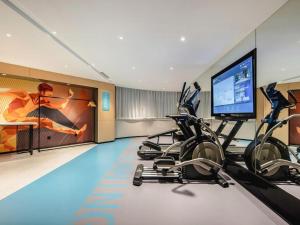 a gym with cardio machines and a flat screen tv at City Comfort Inn Nanning Guangxi University in Nanning
