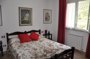a bedroom with a bed with red pillows at Bed & Breakfast 4U PARCHEGGIO INTERNO in Chiavari