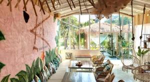 a room with chairs and tables and a pink wall at The State Resort in Ban Wat Phrik
