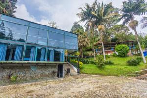 ein Haus mit blauen Fenstern und Palmen in der Unterkunft Finca Hotel Santo Tomas Campestre in Rionegro