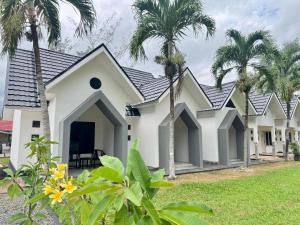 a house with palm trees in front of it at Padmara Hotel in Bengkulu