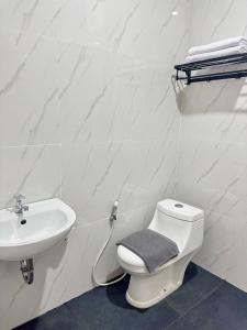 a bathroom with a toilet and a sink at Padmara Hotel in Bengkulu
