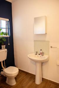 Un baño con lavabo blanco y inodoro. en MacLeod House, en Bloemfontein