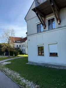 Una gran casa blanca con un patio de césped. en Das Genner - Suite am Bisamberg, en Klein-Engersdorf