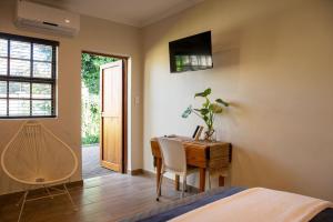 1 dormitorio con escritorio y mesa con silla en MacLeod House, en Bloemfontein