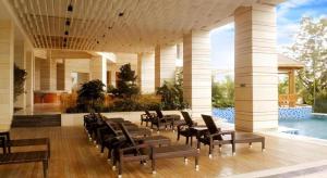 a room with chairs and a pool in a building at Man Wan Harmona Resort in Youcaopeng