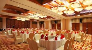 a large banquet hall with white tables and chairs at Man Wan Harmona Resort in Youcaopeng +224 photos