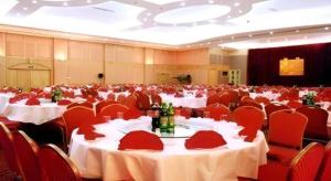 a large banquet hall with white tables and red chairs at Telecom International Hotel in Kunming +184 photos