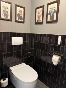 baño con aseo y 3 cuadros en la pared en Das Genner - Suite am Bisamberg, en Klein-Engersdorf 18 fotos más