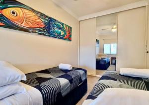 パースにあるSandcastles At The Beach Outstanding Location!の壁に絵が飾られた部屋にベッドが2つある +66枚の写真