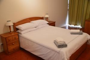 1 dormitorio con 1 cama blanca y 2 toallas en Portugal Algarve Beach Apartment, en Portimão