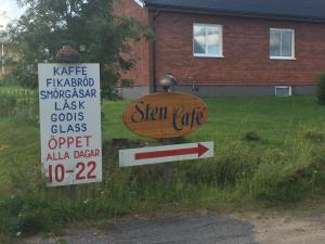 a sign for a sign cafe in front of a house at Stuga vid Hedenäsets stencafé in Hedenäset