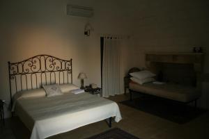 a bedroom with a bed and a bench in a room at Masseria Lacco in Muro Leccese