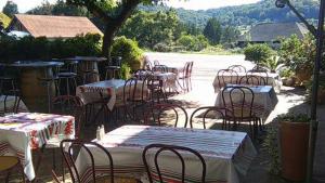 a group of tables and chairs with tables and tablesearcher at Logis L'Auberge Basque in Ozon