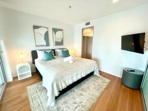 a bedroom with a large bed and a flat screen tv at Ocean View Spa Apartment in Q Tower in Gold Coast +13 photos