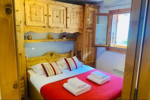 a bedroom with a bed with two towels on it at Alpine Cocoon at 5 min On foot from the cable car in Les Houches