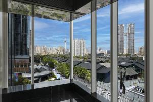 a view of a city from a building window at ISEYA Serviced Apart-ment Chengdu Taikoo Li Flagship in Chengdu