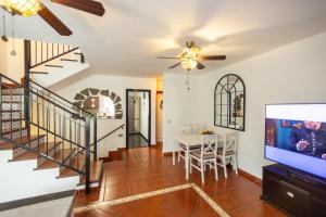a living room with a tv and a dining room at Sweet Home Botanico in Adeje