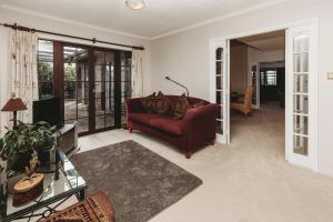 a living room with a red couch and a table at Family Fun - 4BR home with swimming pool and spa in New Plymouth