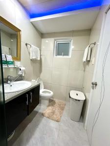 a white bathroom with a sink and a toilet at Deluxe room with king bed and Balcony at Kandi Palace in Angeles