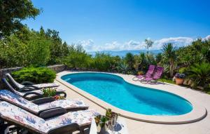 - une piscine avec 2 chaises longues et une table dans l'établissement Villa Anamia with seaview by Villas Guide, à Šodići