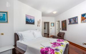 une chambre avec un lit blanc et une chaise dans l'établissement Villa Anamia with seaview by Villas Guide, à Šodići 65 autres photos