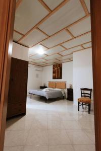 a large bedroom with a bed and a chair at B&B san francesco camera gialla in Oliena