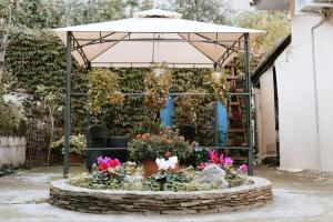 a garden center with flowers and an umbrella at B&B san francesco camera gialla in Oliena