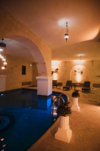 a swimming pool in a building with an archway at Yılkı Cave Suites in Mustafapaşa