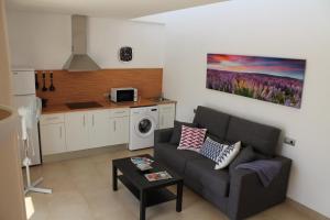 a living room with a couch and a kitchen at Villa Romaní Apartament in Ciutadella
