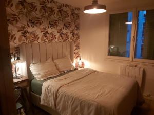 a bedroom with a bed with a white bedspread and a window at Chambre sérénité Montreuil in Montreuil