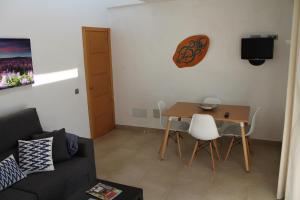 シウタデリャにあるVilla Romaní Apartamentの小さなリビングルーム(テーブル、椅子付)