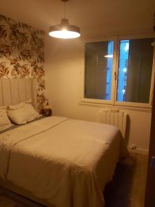 a bedroom with a white bed and a window at Chambre sérénité Montreuil in Montreuil +6 photos