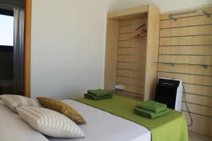 a bedroom with a bed with green towels on it at Villa Romaní Apartament in Ciutadella
