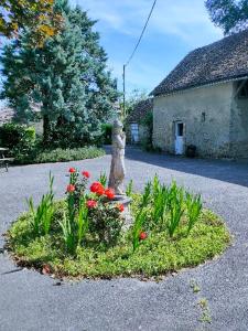 a garden with flowers in the middle of a driveway at Studio "Rêves de gamins" proche du pôle Européen et circuit des 24h, Champagné in Champagné