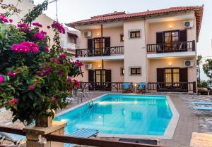 a villa with a swimming pool in front of a house at Amarandos Rethimno's Villa in Roussospítion