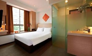 a bedroom with a bed and a bathroom with a sink at RedDoorz Premium @ Balestier in Singapore