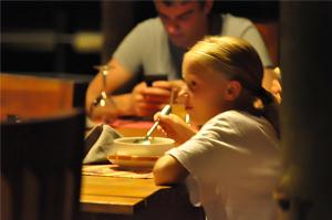 a young girl sitting at a table eating food at Kottawatta Village in Udawalawe