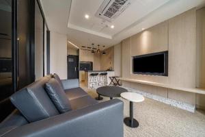 Una sala de estar con un sofá, una mesa y un televisor. en Kintex by K-tree, en Isan