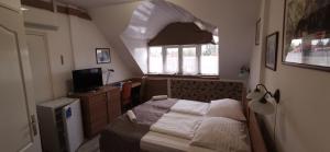 Un pequeño dormitorio con una cama y un televisor. en Hotel Balaton Fonyód, en Fonyód