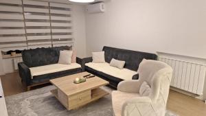 a living room with two couches and a coffee table at Apartman Sunce in Zenica