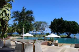 a resort with a pool and tables and umbrellas at Tanjung Lesung Beach Hotel in Kalicaah