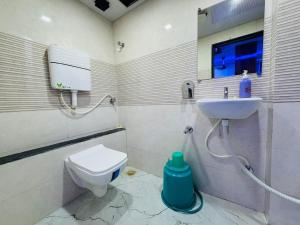 a bathroom with a toilet and a sink at Hotel Welcome Airoli in Navi Mumbai